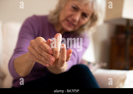 Senior donna a casa la sofferenza con artrite Foto Stock