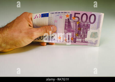 Mano d'uomo tenendo un denaro big bill, 500 euro in una mano. Foto Stock