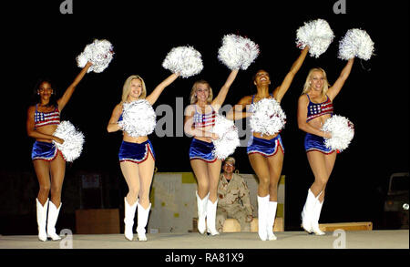 Washington Redskins Cheerleaders e procedure guidate ballerini si combinano per eseguire uno spettacolo di varietà per la distribuito ai membri dell'aria 438th gruppo Expeditionary (AEG) in corrispondenza di un avanzamento-posizione dispiegata durante l'Operazione Enduring Freedom. Le cheerleader e ballerini hanno girato il 438th aria gruppo Expeditionary (AEG) e altre basi nella zona di Responsabilità (AOR) per contribuire a rafforzare il morale delle truppe dispiegate con spettacoli di varietà costituita da canti e balli. Foto Stock