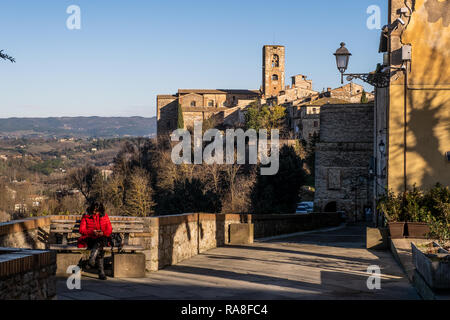 COLLE VAL D'elsa, Italia - 26 dicembre 2018: donna sconosciuta e vista panoramica con le torri della chiesa di Santa Caterina e il Praetorian Palac Foto Stock