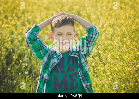 Bel ragazzo con capelli biondi di canola field. Foto Stock