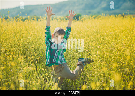 Bel ragazzo con capelli biondi di canola field. Foto Stock