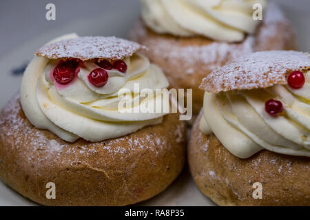 Close-Up di Swedish Semla dolci con mirtilli rossi sul tavolo di legno Foto Stock