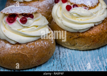 Swedish Semla dolci con mirtilli rossi sul tavolo di legno Foto Stock