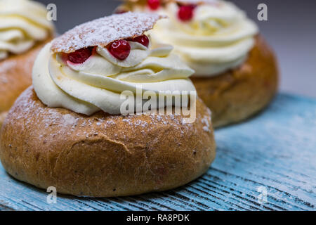 Close-up di Swedish Semla dolci con mirtilli rossi su legno Foto Stock