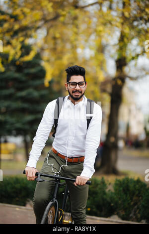 Indian uomo Bicicletta Equitazione a lavorare in città street Foto Stock