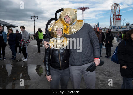 Un giovane che indossa in vecchio stile del sommozzatore caschi posano per una foto prima di annuale di Polar Bear Club New Years Day nuotare a Coney Island, Brooklyn, New York. Foto Stock