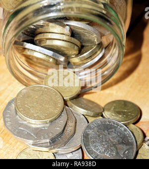 Prendendo delle monete dal vaso di risparmio Foto Stock