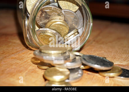 Prendendo delle monete dal vaso di risparmio Foto Stock