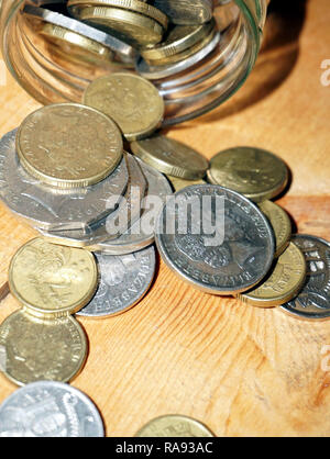 Prendendo delle monete dal vaso di risparmio Foto Stock