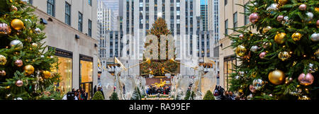 L'albero di Natale al Rockefeller Center circondato dagli angeli, turisti, visitatori e gli edifici. Foto Stock