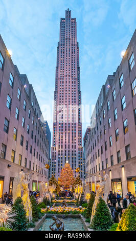 L'albero di Natale al Rockefeller Center circondato dagli angeli, turisti, visitatori e gli edifici. Foto Stock