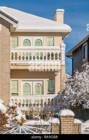 La facciata della nuova casa di lusso nella neve sul cielo azzurro sfondo sulla stagione invernale Foto Stock