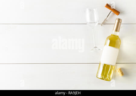 Vino bianco bottiglia con cavatappi, sughero e bicchiere di vino bianco sul tavolo di legno piana da laici al di sopra con lo spazio di copia Foto Stock