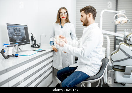 Dentista con giovane donna assistant funziona con computer nello studio dentistico Foto Stock
