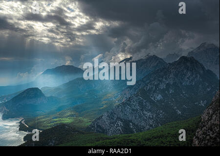 Incredibile paesaggio bello della montagna con nuvole affascinante e morbidi raggi del sole cade sulla terra attraverso le dense nubi. La natura dello sfondo. Posizione orizzontale Foto Stock