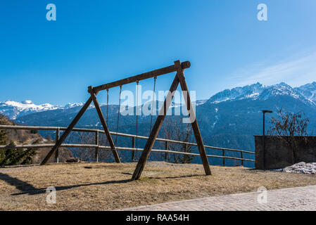 Swing, bambino giochi per bambini, mountain view, montagne coperte di neve - Alpi Italiane vista dal Castello, piccola città, Trento, Trentino, Italia Foto Stock