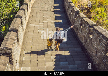 Felice allegro gioioso turisti papà e figlio presso la Grande Muraglia della Cina divertirsi sul viaggio sorridente ridendo e ballando durante il viaggio in Asia. Destinazione cinese. Viaggiare con i bambini in Cina concetto banner, formato lungo Foto Stock