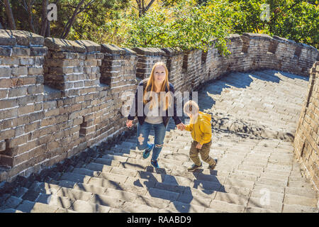 Felice allegro gioioso turisti madre e figlio presso la Grande Muraglia della Cina divertirsi sul viaggio sorridente ridendo e ballando durante il viaggio in Asia. Destinazione cinese. Viaggiare con i bambini in Cina concept Foto Stock