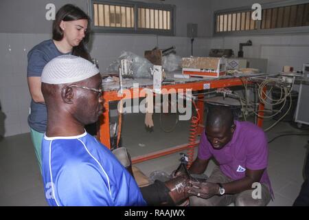 Protesi senegalese Mamadou tecnico Kare, effettua misurazioni per una protesi appena come i militari Usa professionista medico osserva durante la preparazione medica Esercizio 17-1 presso La Sante des Armees ospedale di Dakar in Senegal, gennaio 12, 2017. MEDRETE è uno sforzo combinato tra il governo senegalese, U.S. Army Africa, Stati Uniti La riserva di esercito 332Brigata Medica di Nashville, Tennessee, e il Vermont Air National Guard. (AFRICOM)'s MEDRETEs ospitato da Stati Uniti Army-Africa coppia piccole squadre di militari professionisti medici da parte degli Stati Uniti con la partecipazione di partner africani compit Foto Stock