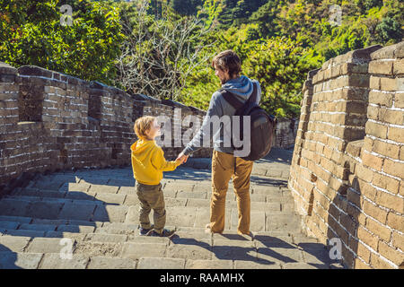 Felice allegro gioioso turisti papà e figlio presso la Grande Muraglia della Cina divertirsi sul viaggio sorridente ridendo e ballando durante il viaggio in Asia. Destinazione cinese. Viaggiare con i bambini in Cina concetto banner, formato lungo Foto Stock