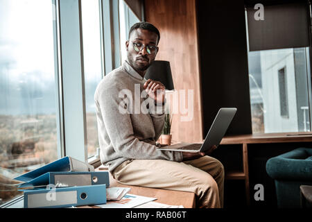 Attento freelance internazionale essendo nel profondo di pensieri Foto Stock