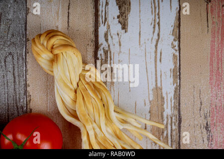 Home affumicato formaggio rustico sulla vecchia scheda. close up e pomodori Foto Stock