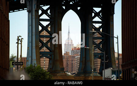 Spettacolare vista dell'Empire State Building visto attraverso la Manhattan Bridge in Dumbo quartiere. Foto Stock