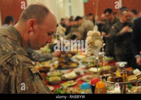 Un U.S. Viste soldato scelte alimentari durante una cena informale nel palazzo di cristallo sulla sicurezza della Polonia giorno in Zagan, Polonia, 14 gennaio 2017. Stati Uniti I soldati dell esercito assegnati al 3° Brigata corazzate contro la squadra, 4a divisione di fanteria, arrivati di recente in Polonia, segnando l'inizio di back-to-back rotazioni delle brigate corazzate in Europa come parte di Operazione Atlantic risolvere. Veicoli e attrezzature per un totale di oltre 2.700 pezzi, vengono spediti in Polonia per la certificazione prima della distribuzione in tutta Europa per l'uso nella formazione di nazioni partner. Questa rotazione aumenterà la capacità di dissuasione in r Foto Stock