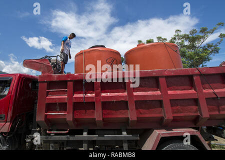 Palu, Sulawesi centrali, Indonesia. 3 gennaio 2019. Lavoratori riempire di acqua pulita per i campi profughi in Balaroa, Palu, Sulawesi centrali Villaggio Camp integrato, Indonesia, giovedì (1/3/2019). Dopo essere entrato in un prolungamento della fase di emergenza o tre mesi dopo il disastro, i rifugiati hanno cominciato a sentire la difficoltà di acqua pulita in quanto l'alimentazione dai volontari era in calo e nel frattempo non ci sono state fonti di acqua in campo. Credito: bmzIMAGES/Alamy Live News Foto Stock