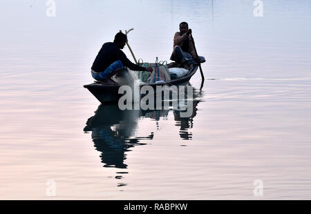 Assam, India. 3 gennaio, 2019. I pescatori indiani gettare la sua rete da pesca in fiume Brahmaputra durante il tramonto a Guwahati giovedì 3 gennaio, 2019. Foto: DAVID TALUKDAR. Credito: David Talukdar/Alamy Live News Foto Stock