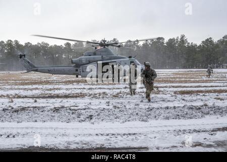 New Jersey Esercito Nazionale soldati di guardia con l'1-114th fanteria corsa verso la woodline dopo un inserimento di aria dalla Marine Aircraft Group 49 UH-1Y Huey elicotteri durante una formazione congiunta esercita su base comuneGuire-Dix Mc-Lakehurst, N.J., 10 gennaio, 2017. Il Marine Corps riserva prevista airlift e chiudere il supporto aereo alla società alfa di soldati di 1-114. Il 1-114, che è parte del cinquantesimo della brigata di fanteria combattere Team, sta partecipando a una serie di eventi formativi che culmineranno questa estate in un combattimento esportabile capacità di formazione esercitare sulla Fort Pickett, Va. l esercito Guardia Nazionale Foto Stock