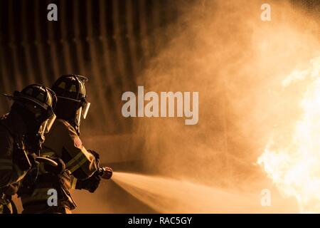 I vigili del fuoco dalla 23d' ingegnere civile Squadron estinguere la fiamma durante le ore notturne, live-formazione antincendio, gen. 10, 2017 a Moody Air Force Base, Ga. Questo corso di formazione è un fabbisogno annuale per Moody vigili del fuoco ed è solo uno dei modi in cui stare pronti a proteggere le persone, i beni e l'ambiente dagli incendi e disastri. Foto Stock