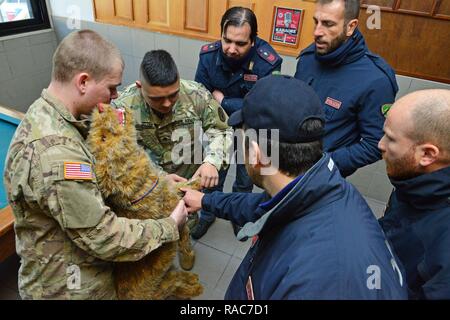 Stati Uniti Army Spc. Jose Armendariz assegnata alla sanità pubblica attività Italia, spiega come effettuare un esame medico su un peluche cane alla polizia italiana Squadra Cinofili K9 aeroporto di Venezia e la Questura di Padova e U.S. Air Force a Caserma Ederle, Vicenza, Italia, Gennaio 17, 2017. Militari di cane da lavoro le squadre sono utilizzati in pattuglia, farmaco e rilevamento esplosivi e specializzato funzioni di missione per il Dipartimento della difesa e di altre agenzie governative. Il militare 525th cane da lavoro di distacco, la formazione congiunta con la polizia italiana Squadra Cinofili K9 aeroporto di Venezia e la Questura di Padova Foto Stock