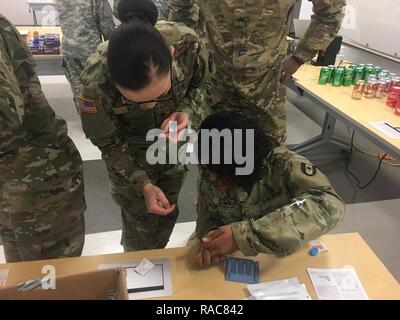 Spc. Kendra Ruiz, un medico specialista di laboratorio con la prima area di laboratorio medico, dirige Sgt. Natascia Sims, un veterinario ispezione alimenti specialista anche con 1° AML, su come fare spessi e sottili di strisci di sangue durante il primo AML operative della Clinica di Malattie Infettive in corso presso l'Mallette Training Facility in Aberdeen Proving Ground, Maryland da 10-12 gennaio oltre 50 partecipanti provenienti da 10 enti hanno beneficiato del localmente-accreditato di tre giorni del corso e da docenti di diverse organizzazioni. Foto Stock