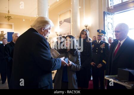 Presidente-eletto Trump, sinistra, riceve un regalo da Karen Durham-Aguilera, centro, direttore esecutivo dell Esercito Nazionale i cimiteri militari, a seguito di una ghirlanda di cerimonia di posa in Al Cimitero Nazionale di Arlington, Gennaio 19, 2017, in Arlington, Virginia Trump e vice presidente-eletto Mike Pence deposto una corona presso la tomba. Foto Stock