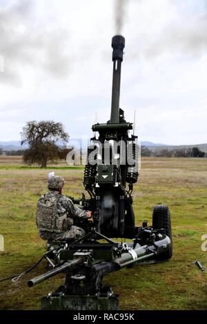 Un soldato dell'esercito assegnato al Bravo batteria, 1-143Campo rd artiglieria, test incendio di un M119A3 105mm obice a Camp Roberts, California, 18 gennaio 2017. Foto Stock