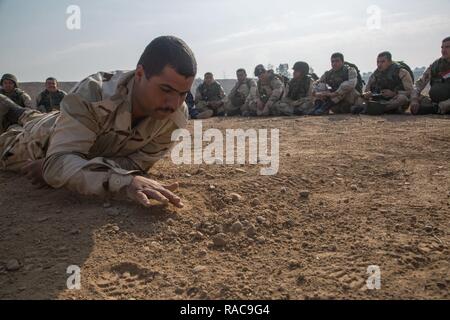 Una delle forze di sicurezza irachene soldato rivela fili che conducono ad una improvvisata dispositivo esplosivo durante il corso di formazione di Camp Taji, Iraq, Gennaio 17, 2017. Soldati britannici insegnare ISF le competenze necessarie per identificare e scoprire IED di diminuire le perdite di vite umane e di aumentare il loro successo sul campo di battaglia. Le forze della coalizione hanno condotto la formazione a sostegno della Combined Joint Task Force - Funzionamento inerenti risolvere la coalizione globale per sconfiggere ISIL in Iraq e la Siria. Foto Stock