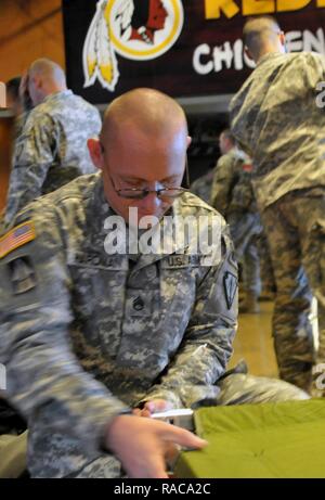 Il personale dell'esercito Sgt. Jeremy Hardman, 84ma la polizia militare da Indianapolis, Ind. prepara il suo lettino, Gen 18 al campo di FedEx, Landover, Md., durante in elaborazione per la 58th inaugurazione presidenziale. Più di 7.500 soldati e aviatori da 44 membri, 3 territori e il Distretto di Columbia di sostenere gli enti locali e le autorità federali per evento inaugurale. Foto Stock