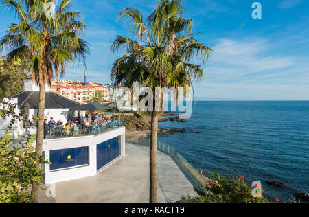 Persone sedute ad alto livello terrazza che si affaccia sul mar mediterraneo, Benalmadena, Andalusia, Spagna. Foto Stock