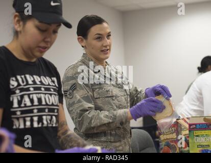 Senior Airman Bernadette Galindo, sinistra, xi delle forze di sicurezza Elite Squadron guardia di gate e il Senior Airman Emily Pearce, destra, xi il supporto per la sicurezza unità squadrone scheduler, preparano panini a base comune Andrews, Md., per una comunità unità nel riconoscimento di Martin Luther King Jr. il giorno 25 gennaio, 2017. Volontari disposti a circa 300 insaccata al sacco a mano a membri di comunità in stato di bisogno presso la Comunità creativi per la Nonviolenza in Washington D.C. Foto Stock