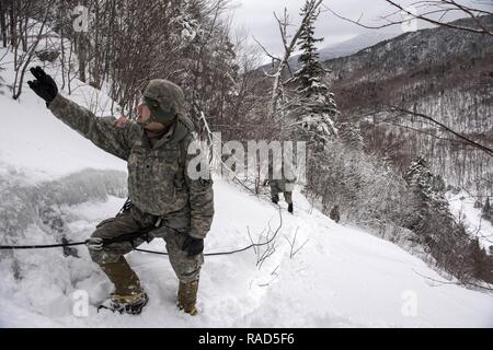 Stati Uniti Soldati provenienti da società alfa, 3° Battaglione, 172nd Reggimento di Fanteria, 86a brigata di fanteria combattere Team (montagna), Vermont Guardia nazionale, partecipare ad una passeggiata in montagna a Smugglers' Notch in Jeffersonville, Vt., Gennaio 28, 2017. Come parte del loro inverno formazione annuale, i soldati hanno migliorato le loro conoscenze alpinistiche in sci, arrampicate su ghiaccio e rappelling. Foto Stock