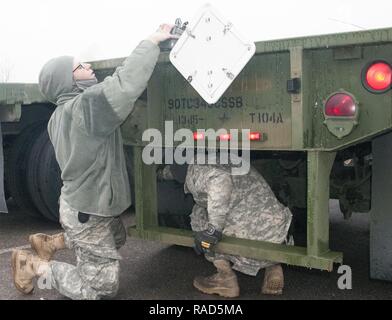 Oklahoma Esercito Nazionale guardie Spc. Heather Henderson (sinistra) e SPC. Jay Chadwell (a destra), entrambi membri del 1245th Transportation Company, novantesimo squadrone comando, modificare un fanale posteriore 14 gennaio 2017, in preparazione per il patriota Bandoleer, il trasporto a lungo raggio la missione di circa 3.400 miglia da Oklahoma a Concord, California, e all'indietro. La missione è a sostegno del funzionamento Golden Patriot portato dalla California Army National Guard, un multi-funzionamento dei componenti compresi Esercito Nazionale Guardia, Riserva e Active-Duty soldati. Foto Stock