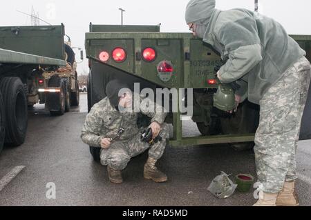 Oklahoma Esercito Nazionale guardie Spc. Jay Chadwell (sinistra) e SPC. Heather Henderson (destra), entrambi membri del 1245th Transportation Company, novantesimo squadrone comando, modificare un fanale posteriore 14 gennaio 2017, in preparazione per il patriota Bandoleer, il trasporto a lungo raggio la missione di circa 3.400 miglia da Oklahoma a Concord, California, e all'indietro. La missione è a sostegno del funzionamento Golden Patriot portato dalla California Army National Guard, un multi-funzionamento dei componenti compresi Esercito Nazionale Guardia, Riserva e Active-Duty soldati. Foto Stock