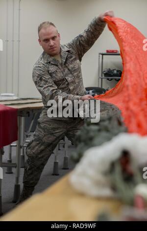 Airman 1. Classe Brent T. Spencer, 374 Operations Support Squadron equipaggi di volo volo apparecchiature apprendista, pre-pack di un paracadute tettoia gen. 31, 2017 a Yokota Air Base, Giappone. Il volo AFE è responsabile per la riparazione, imballaggio, e tutto intorno la manutenzione dei paracadute utilizzati da equipaggi e sopravvivenza, evasione, la resistenza e la fuga degli specialisti. Foto Stock