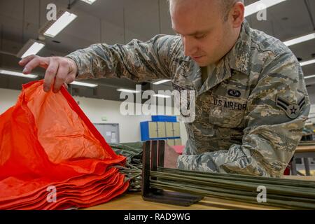 Airman 1. Classe Brent T. Spencer, 374 Operations Support Squadron equipaggi di volo volo apparecchiature apprendista, controlla il canale di aria di una tettoia di paracadute gen. 31, 2017 a Yokota Air Base, Giappone. Il volo AFE è responsabile per la riparazione, imballaggio, e tutto intorno la manutenzione dei paracadute utilizzati da equipaggi e sopravvivenza, evasione, la resistenza e la fuga degli specialisti. Foto Stock