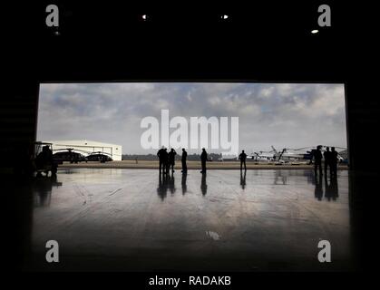 Aria agenti di interdizione e di speciali gruppi di risposta degli Stati Uniti Delle dogane e della protezione delle frontiere, raccogliere in un hangar prima di un esercizio di formazione in quanto forniscono la sicurezza dello spazio aereo per il Super Bowl LI, in Conroe, Texas, 1 febbraio 2017. Unità con aria e marini e le operazioni di ufficio di operazioni sul campo teamed in su con la Civil Air Patrol per mettere in pratica un'aria-aria intercettare utilizzando due AMO UH-60 Black Hawk elicotteri e due C-550 Citation Jet per rintracciare la simulazione di una incursione nel ristretto spazio aereo. Stati Uniti Delle dogane e della protezione delle frontiere Foto Stock