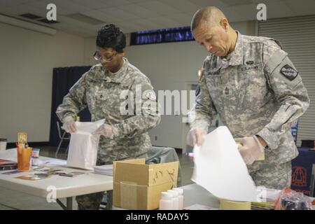 Master Sgt. Troy marrone (a destra) un network operations noncommissioned officer e nativo di Fayetteville, North Carolina, assegnato alla sede centrale e sede Company, 359 Teatro segnale tattico brigata, 335a comando di segnalazione (teatro), lungo con Sgt. 1. Classe Lashara Simmons, risorse umane noncommissioned officer e nativo di Newbern, North Carolina, assegnato al Comune di abilitazione Capabilites Commnand, 335sc (T) prassi adeguate procedure di spedizione durante un'unità di prevenzione Leader corso impartito al 335sc (T) sede in East Point, Georgia, 2 febbraio. Foto Stock