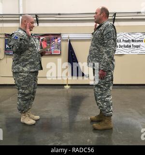 Stato dell'Alaska Defence Force 2 Lt. Ryan Sharratt, comandante del distacco di Kodiak, amministra il giuramento di arruolamento a Pvt. James Glenn presso il Kodiak Readiness Center, Gennaio 21, 2017. ASDF è attivamente il reclutamento di nuovi membri. Foto Stock