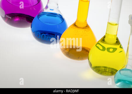 Palloni di chimica in linea diagonale riempiti con soluzioni colorate Foto Stock